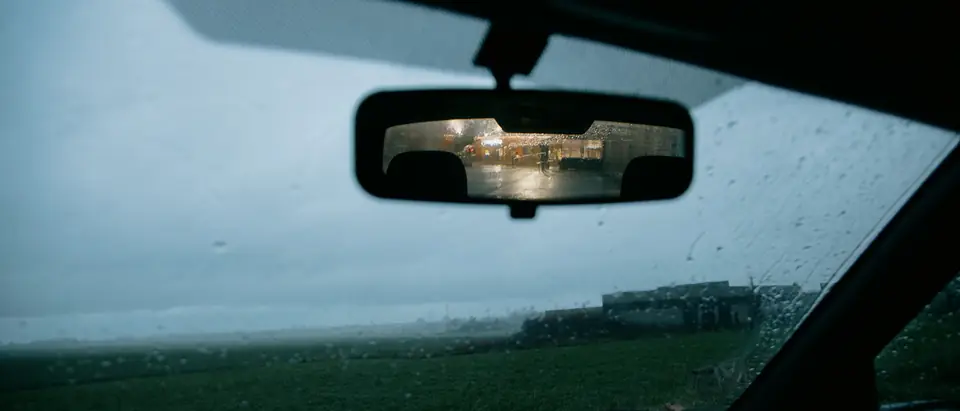 The rearview mirror at the top of a windshield, where the forward camera sits