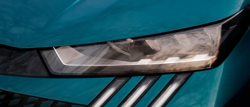 The headlight and grille of a blue car