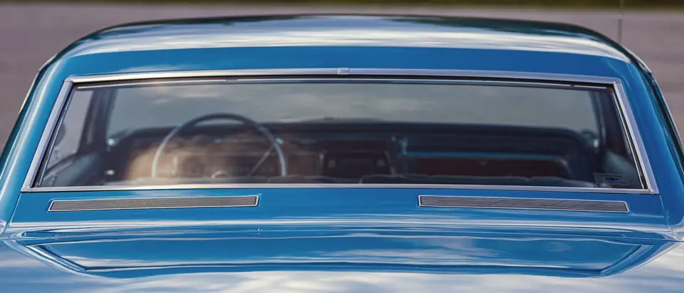 The rear window of a blue classic car