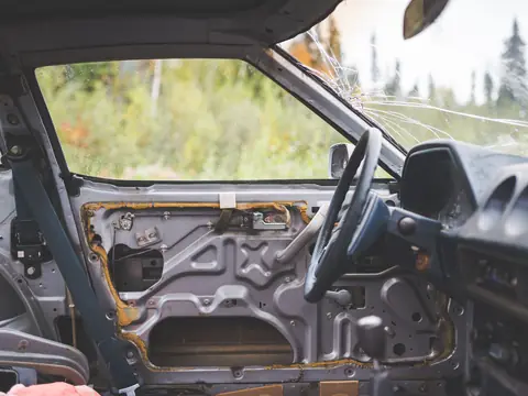 A car door with its trim panel off and the window glass out