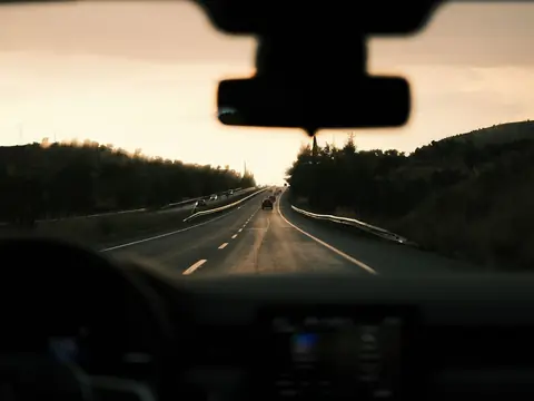 A divided highway at sundown, seen through the windshield