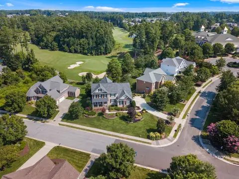 A curving street of houses and trees in the Raleigh area